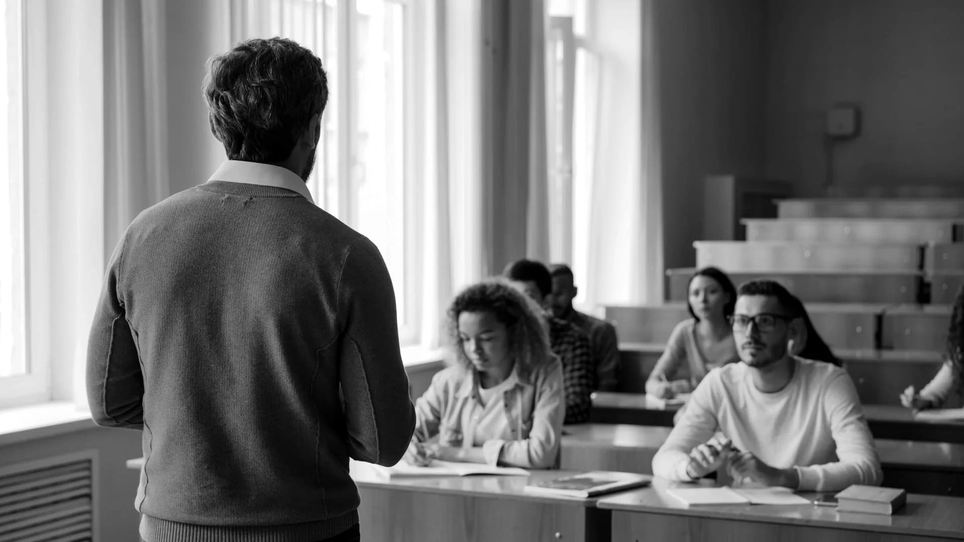 Formateur de dos devant un groupe d'adultes en salle de formation
