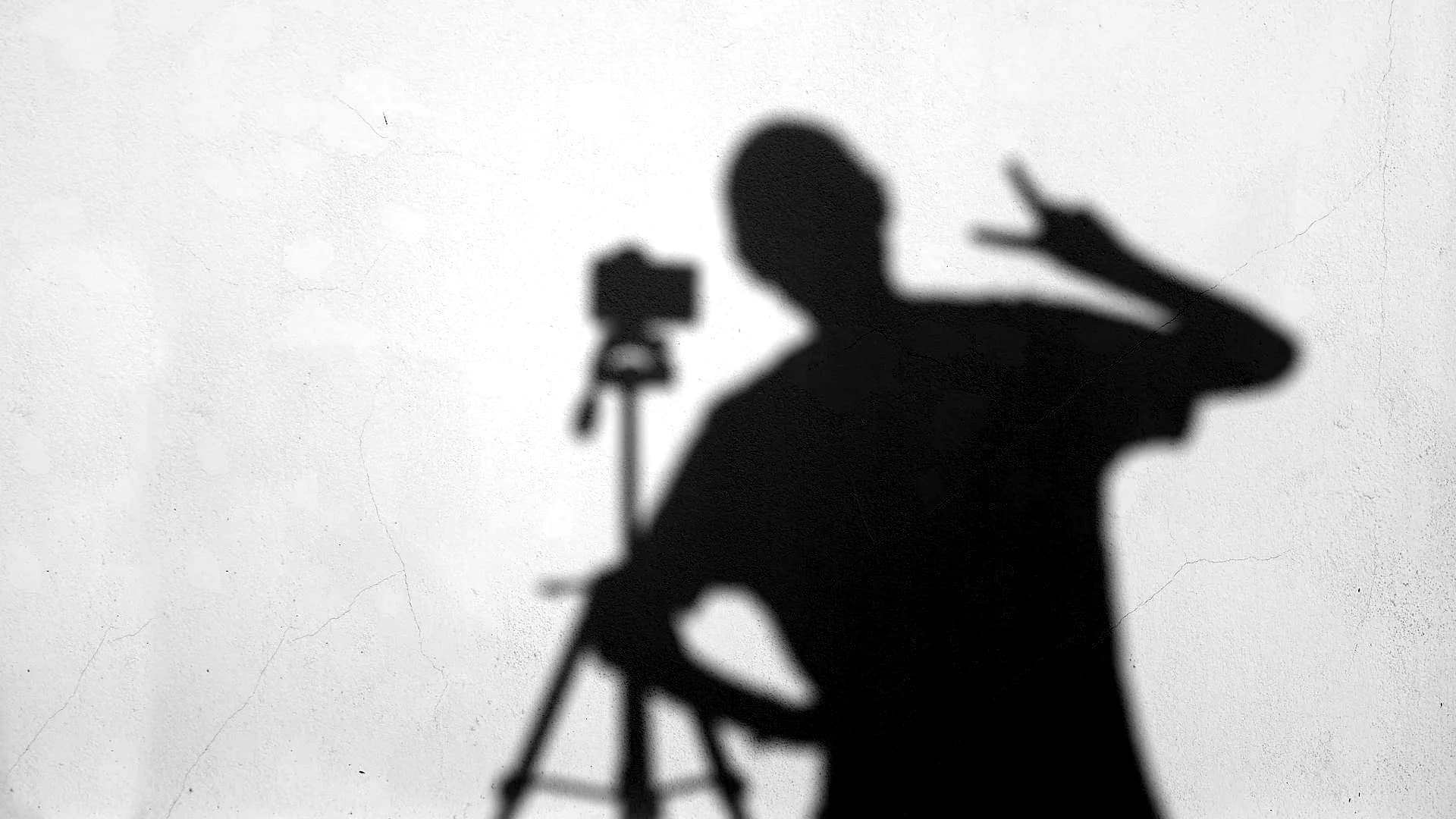 Ombre d'un photographe et de son trépied sur un mur