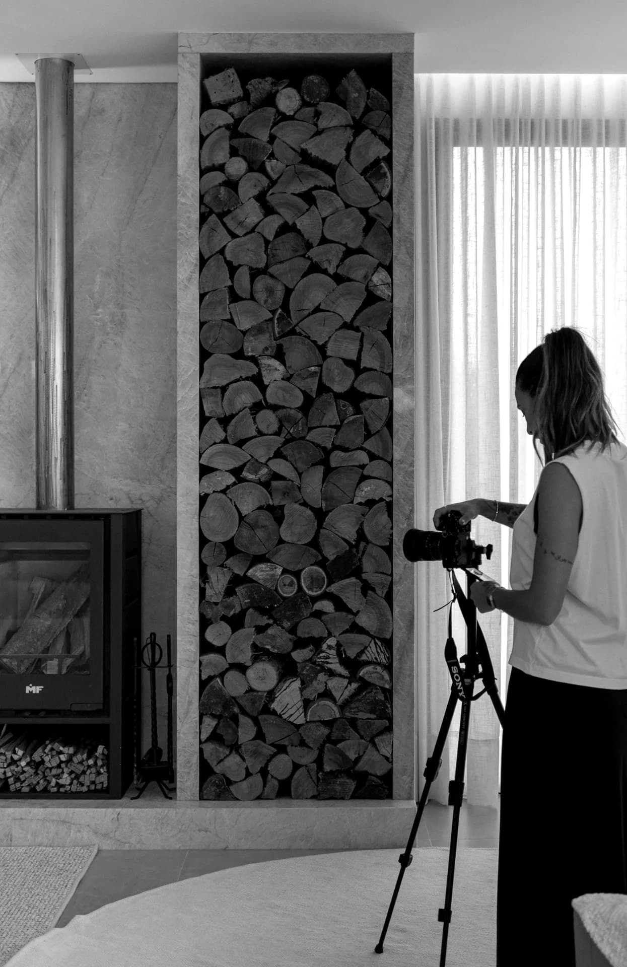 Photographe réglant son appareil sur trépied dans un intérieur
