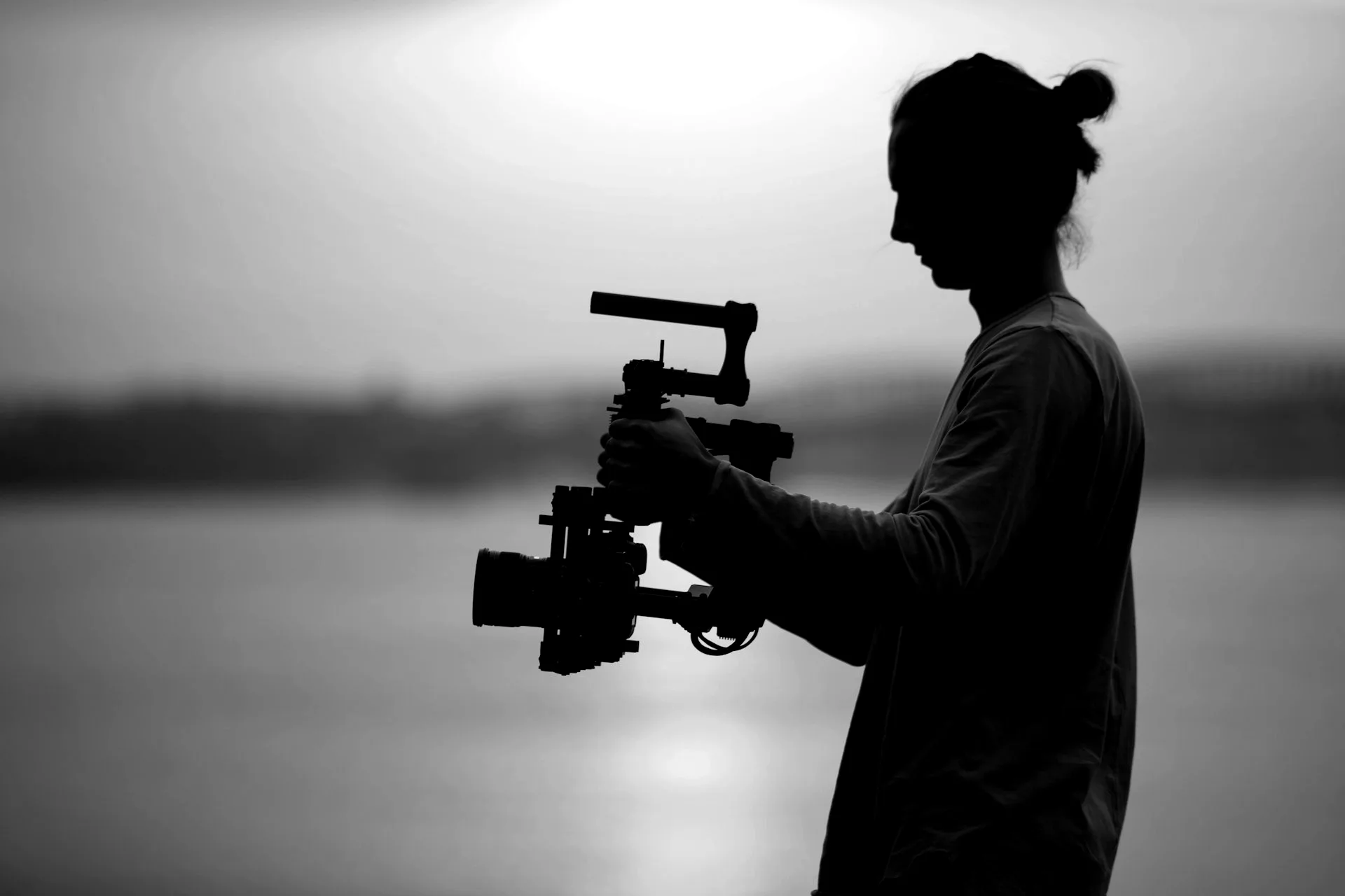 Vidéaste avec stabilisateur en contre-jour