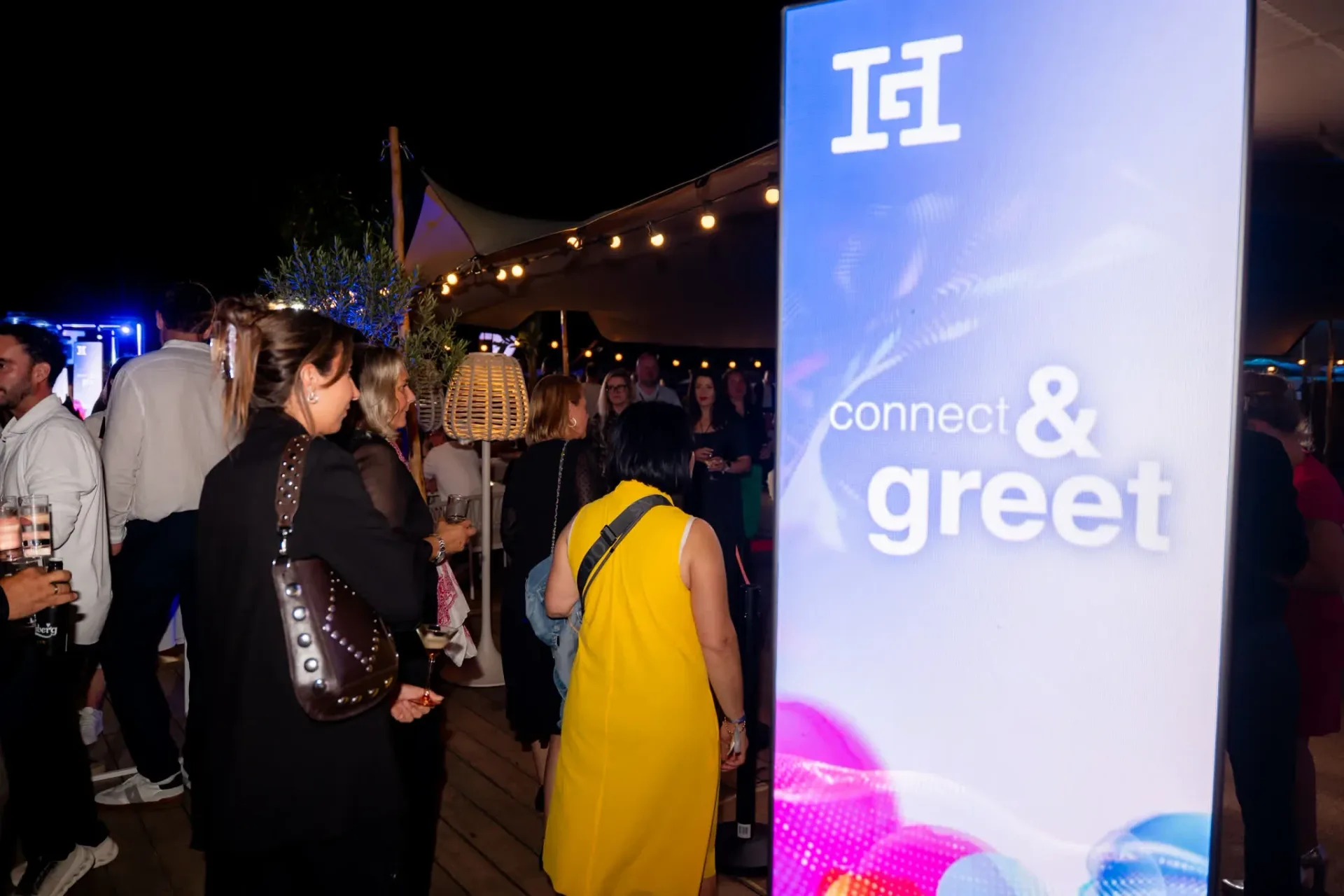 Accueil des invités devant le panneau Connect & Greet, zone d'accueil et de dégustation de la soirée de gala Heinemann à Cannes, photographie événementielle.