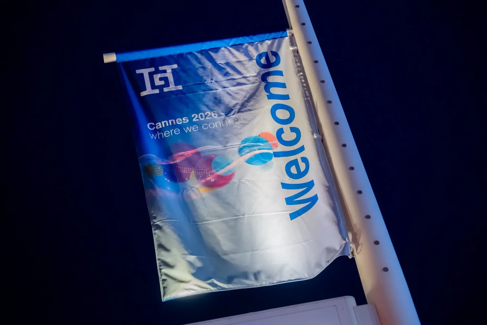 Drapeau Welcome aux couleurs de Cannes 2026 where we connect, accueil de la soirée de gala Gebr. Heinemann sur la plage du Palais Stéphanie, reportage photo événementiel de nuit.