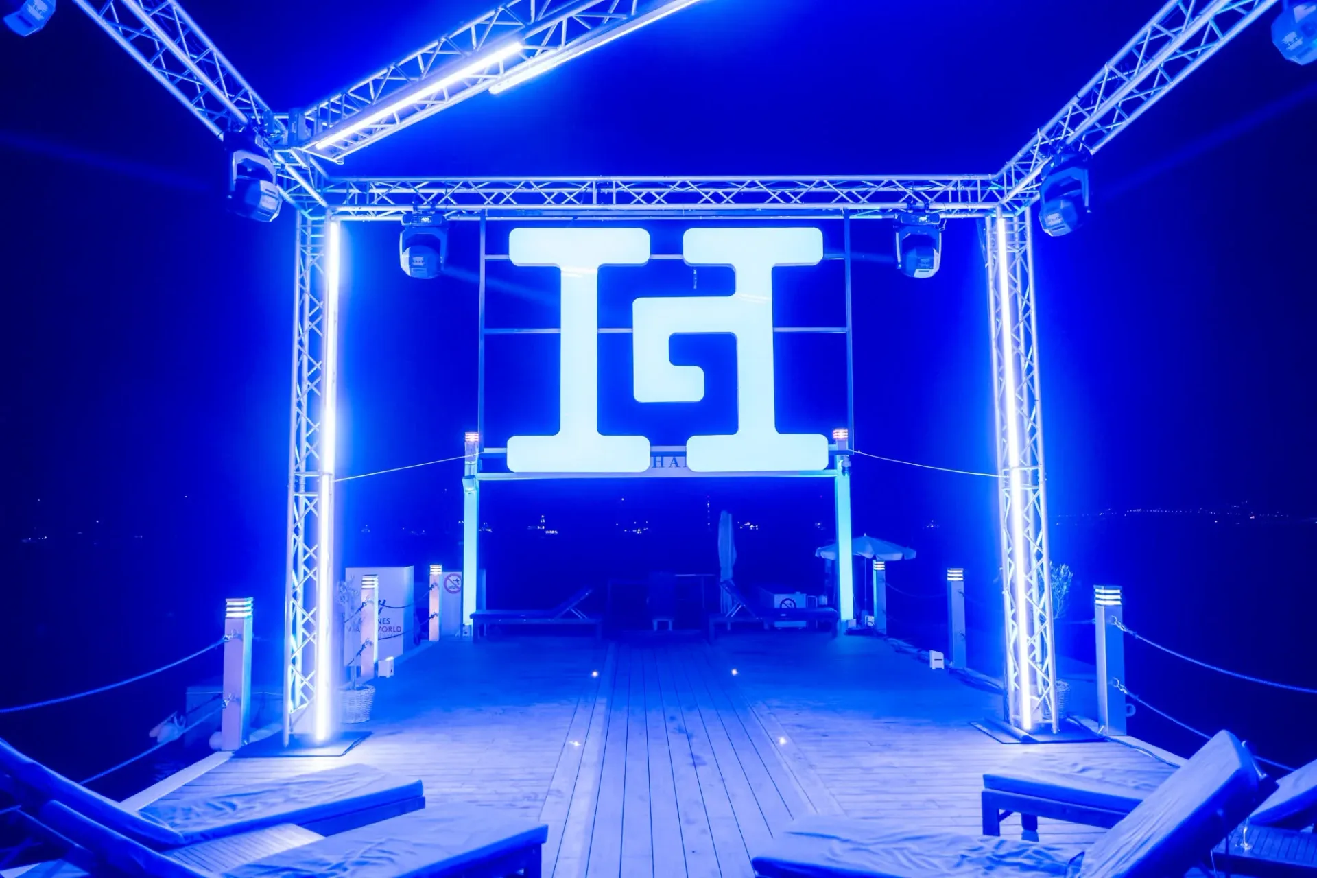 Structure lumineuse bleue avec le logo Heinemann sur le ponton du Palais Stéphanie Beach, de nuit, décor de la soirée de gala d'entreprise à Cannes.