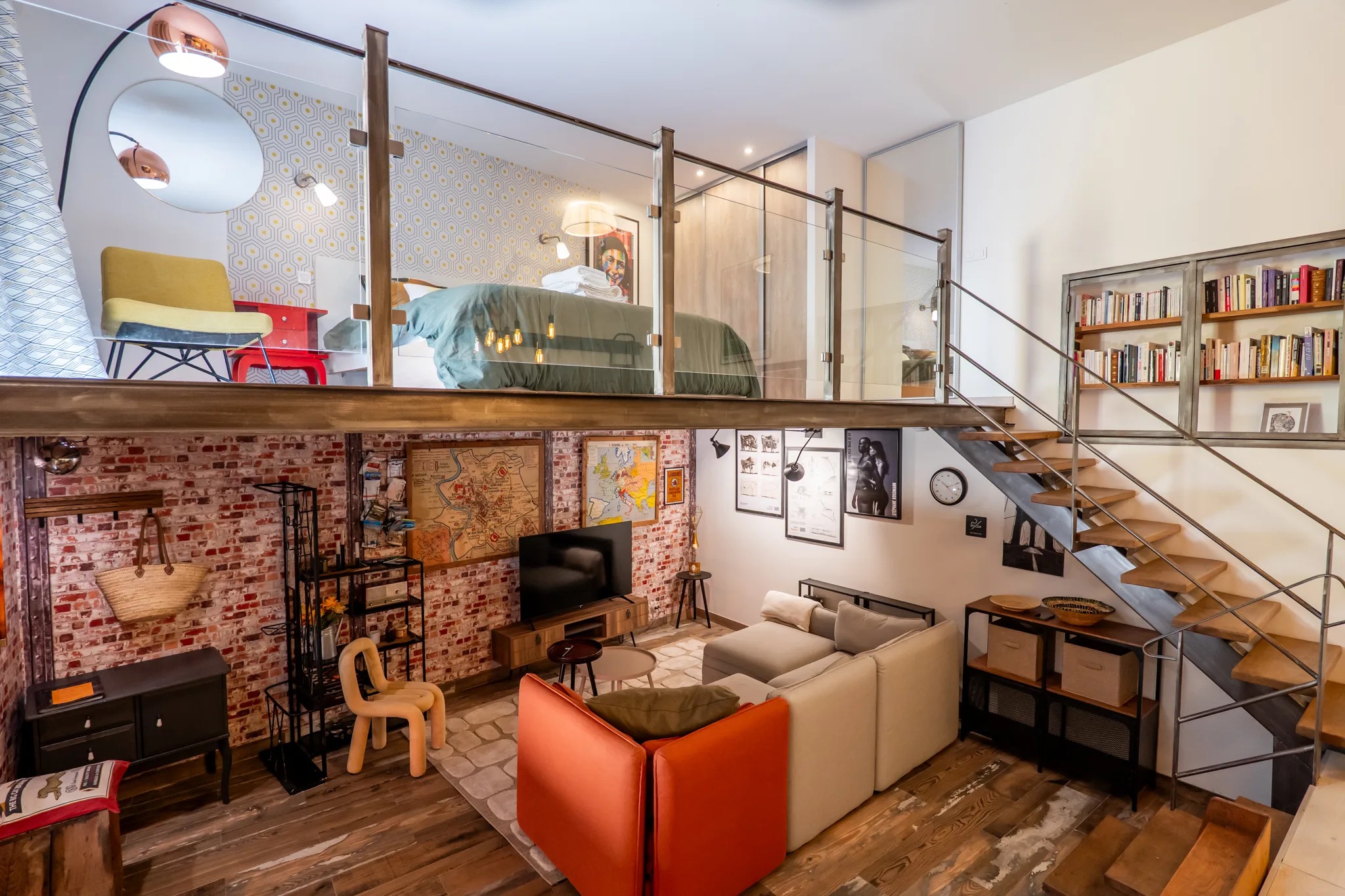 Vue globale du loft industriel avec mur de brique, mezzanine et mobilier design coloré à Manosque.
